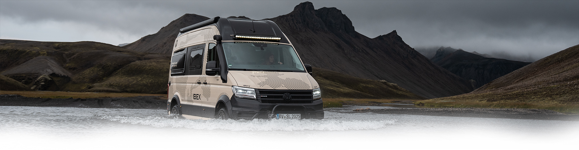 Ein weißer Camper Van steht in einer großen Pfütze.