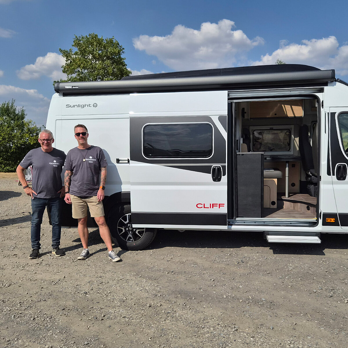 Zwei Personen vor einem weißen Camper Van