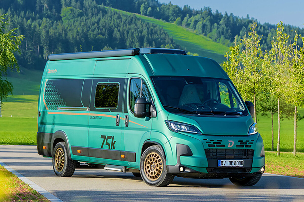 Ein grüner Camper Van in einer Landschaft.