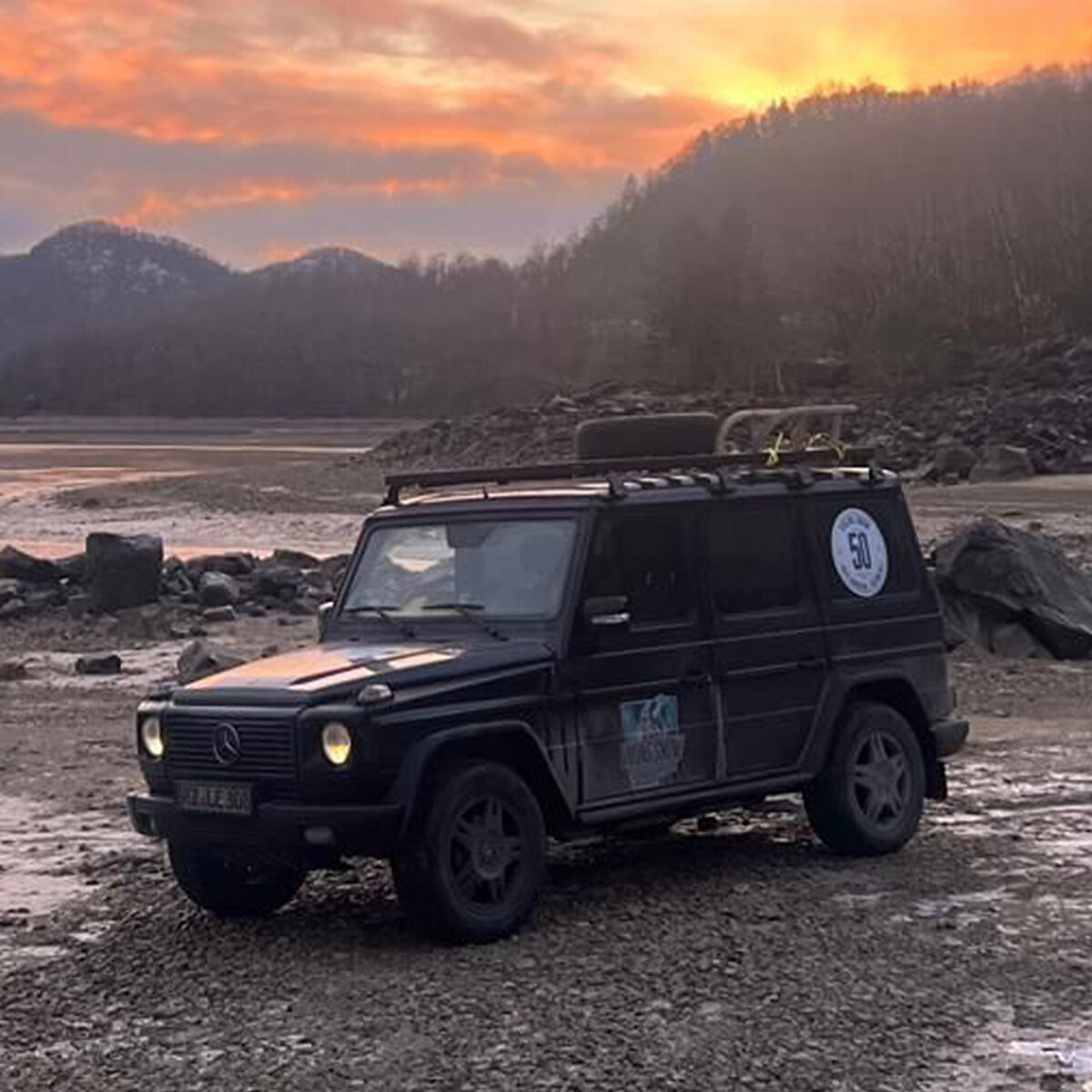 Dunkles Auto in einer Berglandschaft.