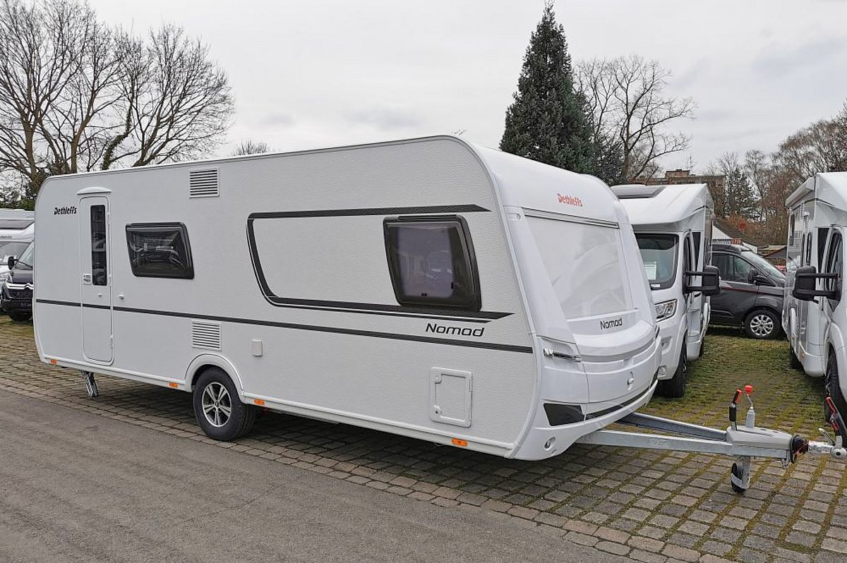 Ein weißer Wohnwagen mit dezenten schwarzen Details auf dem Gelände der Firma Caravanzeit.