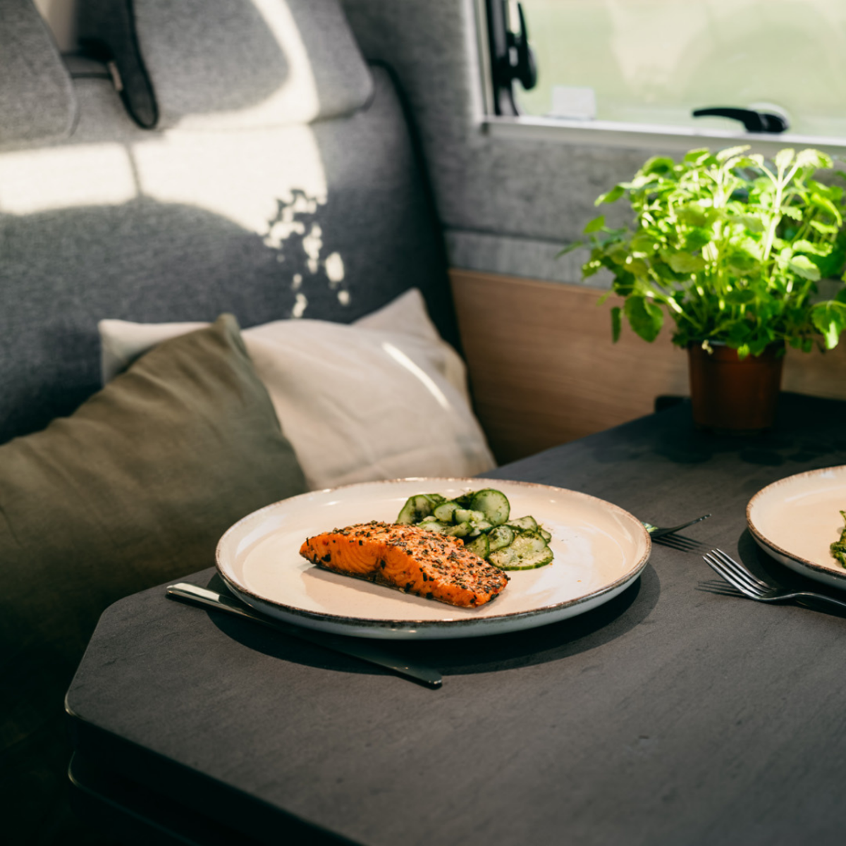 Der Sitzbereich in einem Wohnmobil mit einem gefüllten Teller auf dem Tisch.