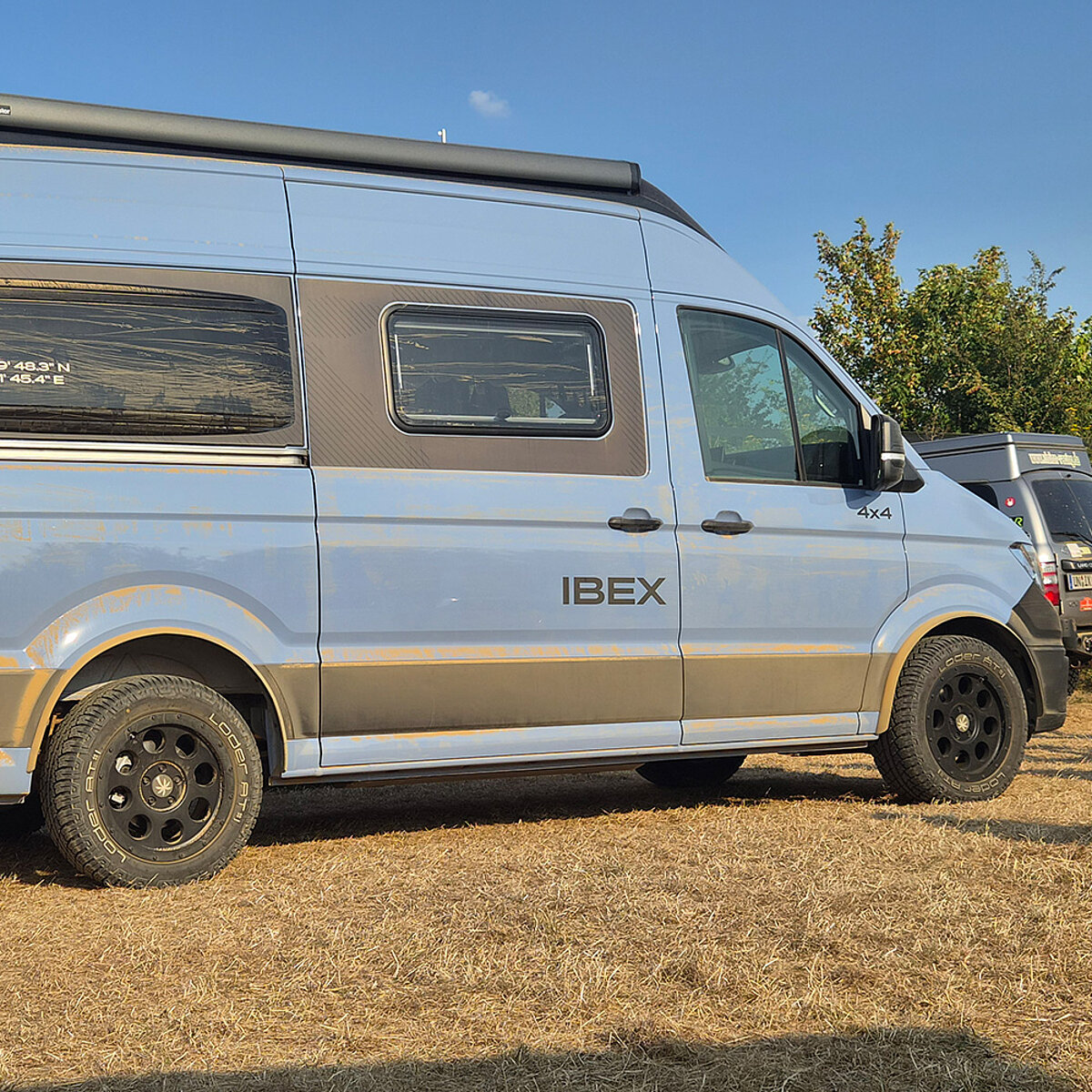 Blauer Camper Van von der Seite.